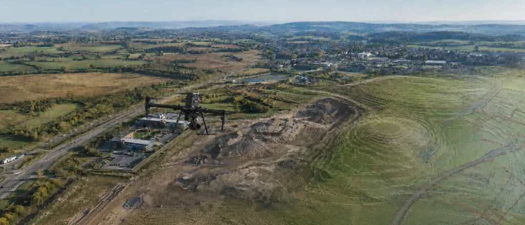 Aerial drone surveying a development site with terrain mapping data