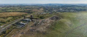Aerial drone surveying a development site with terrain mapping data