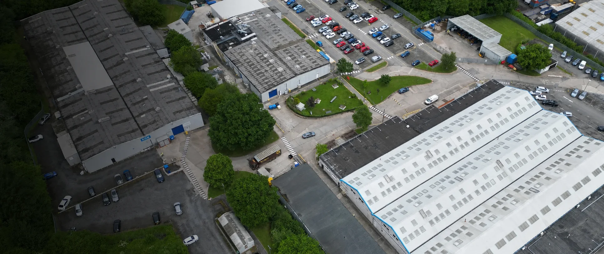 Aerial drone surveys of a factory site showing rooftop inspection imagery and surrounding industrial buildings