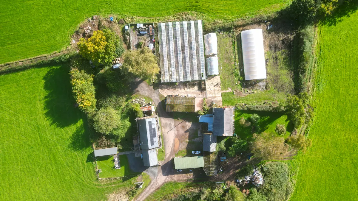 Farm and estate topographical survey aerial view showing rural buildings, glasshouses, access tracks and surrounding agricultural land